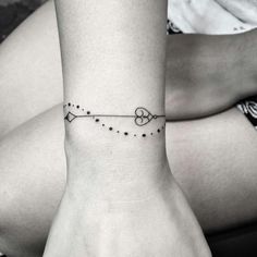 a woman's wrist tattoo with an arrow and stars on the bottom of her arm