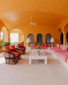 a living room filled with lots of furniture and decor on top of a white floor