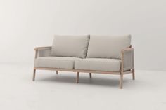 a white couch with two pillows on it's back and the seat upholstered