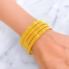 This festive set consists of four bangles, each crafted from 22k yellow gold, weighing a total of 47.9 grams. Embellished with shiny beadwork, these bangles shine with a celebratory sparkle, making them a perfect addition to any festive occasion. Sized at 2.7 with an opening of 2.45 inches, they are designed to fit comfortably while providing a dazzling display of craftsmanship. The beadwork adds texture and depth to the bangles, enhancing their visual appeal and making them stand out in any jewelry collection. Ideal for those looking to add a touch of festivity and elegance to their attire, these bangles merge traditional design with a modern twist. PRODUCT DETAILS Gold Purity(karat): 22k Gold Weight(grams): 47.9 Item Finish: Yellow Gold Bangle Size: 2.7 Bangle Opening: ﻿2.45" Number Of P 45 Number, 22k Gold Bangles, Bridal Diamond Necklace, Diamond Tops, Bridal Jewelry Necklace, Precious Stones Rings, Diamond Pendant Sets, The Bangles, Modern Bracelets