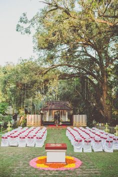 an outdoor ceremony set up with tables and chairs