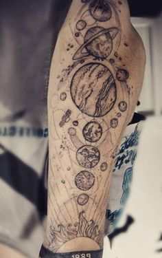 a man's arm with an image of the planets and stars on it in black ink