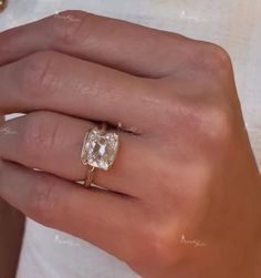 a woman's hand with a ring on it and a diamond in the middle