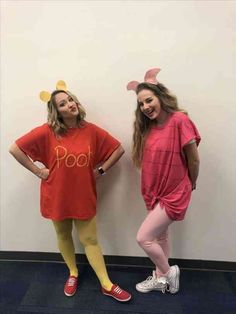 two girls dressed up as winnie the pooh and pigtails posing in front of a wall