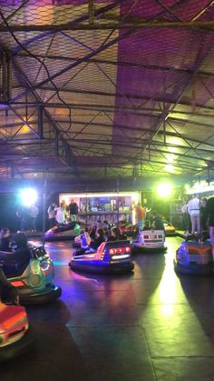 several bumper cars are lined up in an indoor area