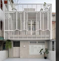 an apartment building with white balconies on the top floor and balcony above it