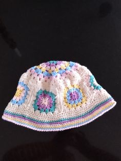 a white crocheted hat with multicolored flowers