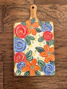 a cutting board with flowers painted on it