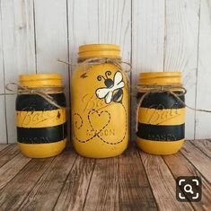 three mason jars with painted bees on them