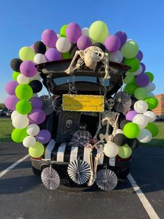 a car decorated with balloons and skeleton decorations