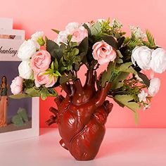 a vase filled with flowers sitting on top of a table next to a photo frame