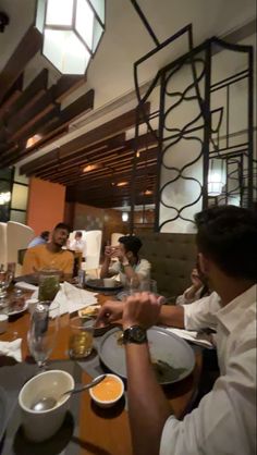 a group of people sitting around a table eating food