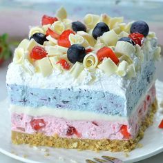 a piece of ice cream cake on a white plate with strawberries and blueberries