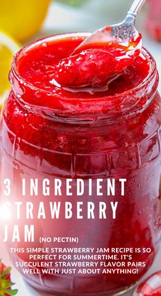 a jar filled with jam sitting on top of a table next to sliced strawberries