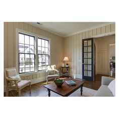 a living room filled with white furniture and lots of windows next to a wooden floor