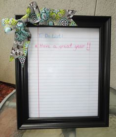 a black frame holding a notepad with a bow on it and the words to do list have a great year