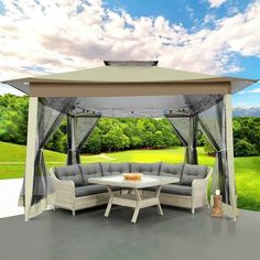 an outdoor gazebo set up on a patio with table and chairs under it, overlooking a golf course