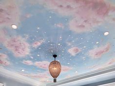 the ceiling is painted with clouds and stars in blue, pink, and white colors