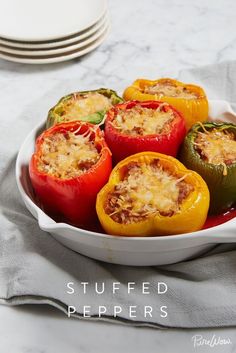 several stuffed peppers in a white dish on a table