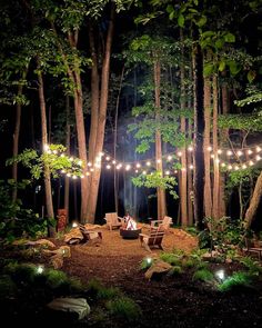 an outdoor fire pit surrounded by trees and lights