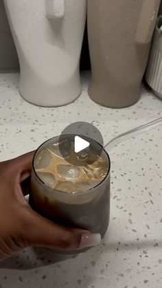 a person holding a cup with liquid in it