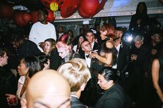 a group of people standing around each other at a party