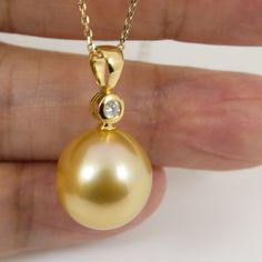 "Lovely pendant made of 18k solid yellow gold with one- 0.06ct. natural mined, large accent diamond and organic natural \"golden\" south sea cultured pearl from Australia. The genuine seawater pearl exhibits excellent high luster, thick nacre & silky-smooth surface; refer to the pictures of the actual pendant for detail. ※ The CHAIN is for display purpose only. It doesn't come with the pendant. Style: Pendant Precious Metal: Solid 18k yellow gold Genuine White Diamond: 1pc / 0.06ct (2.68mm).  ※ Bail Inside Dimension: 3.7*5.0mm Pearl Origin: Broome; Western Australia. Pearl Type: South Sea Cultured Pearl Main Color: Golden Pearl Treatment: None. 100% organic natural color. Pearl Shape: Fine Drop. ------------- Pearl Size (diameter x length): 13.9 x 15.9mm Luster: High Nacre: Thick Surface: Yellow Gold Diamond Jewelry With Pear Shape, Pear-shaped Yellow Gold Diamond Jewelry, Yellow Gold Pear-shaped Diamond Jewelry, Gold Jewelry With Pear-shaped Diamond Accents, Pear-shaped Gold Jewelry With Diamond Accents, Brilliant Cut Yellow Gold Pear Jewelry, Gold Earrings Wedding, Golden South Sea Pearls, Sea Pearl