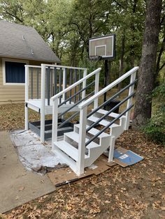 a basketball hoop on the side of a house next to a set of white stairs