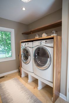 a washer and dryer in a room with a rug on the floor next to it