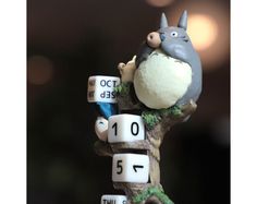 a figurine is sitting on top of a tree branch with numbers in front of it