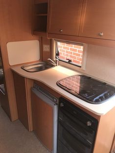 a kitchen area with sink, stove and cabinets in a recreational vehicle or camper