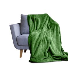 a couch with a green blanket on it and a grey chair in the foreground