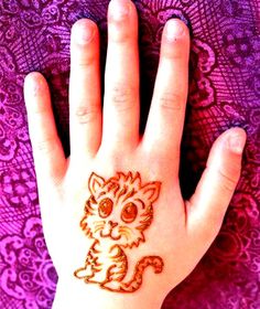 a person's hand with a cat tattoo on it