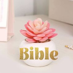 a white vase with a pink flower in it and the words clutterbug above it