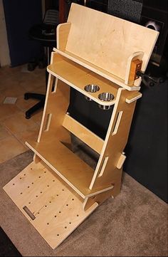 a small wooden stove sitting on top of a floor next to a computer desk and chair