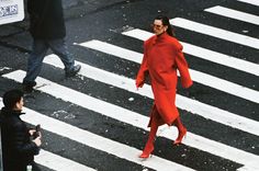 a woman in a red dress crossing the street