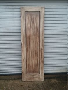 a wooden door sitting in front of a garage