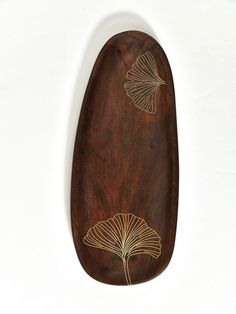 a wooden object with gold leaf designs on it's side, against a white background