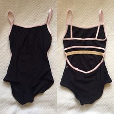 two black and pink swimsuits laying on top of a white bed next to each other