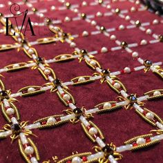 a close up view of beads and chains on a red cloth with gold clasps