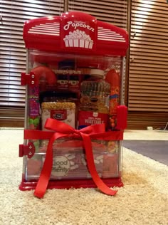 a red vending machine sitting on top of a white carpet covered in condiments