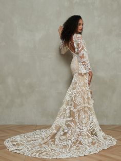 a woman in a wedding dress standing on a wooden floor with her back to the camera