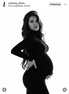 a pregnant woman posing for a photo in black and white with her hands on her hips