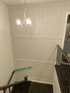 an empty stairwell with white walls and wooden handrails