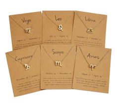 six zodiac necklaces are displayed on brown cards with the names leo and libra