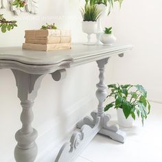 a table with some plants on top of it and two books sitting on the edge