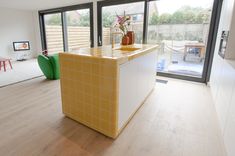 a kitchen island in the middle of a room with sliding glass doors leading to an outside patio