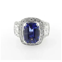 GAI certified 18K White Gold Genuine Tanzanite and Diamond Ring  This statement piece is set in white gold and has a genuine emerald cut blue tanzanite stone measuring at 4.14ct, with a AAA clarity grade.  The stunning tanzanite is blue with purple tones.  Approx. 1.26cts of emerald and round cut diamonds surround the tanzanite stone.  Diamond clarity: VS2 - SI1  Diamond color: G-H  Ring is a size 6.5 and can be sized.  The front of ring is 16.2 mm north to south and 21.1 west to east  This ring sits approx. 9mm above finger.  11.5 g / 7.3 dwt  Very good preowned condition. Just polished and certified by GAI. Certification paperwork included.  Estimated retail replacement value 8,500  Will be shipped priority mail or fed ex with insurance. Tanzanite And Diamond Ring, Art Deco Sapphire Ring, Sapphire Eternity Ring, Art Nouveau Ring, Turquoise Gold Ring, Tanzanite Diamond Ring, Purple Tones, Tanzanite Stone, Blue Tanzanite