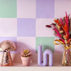 decorative objects displayed on shelf in room with checkerboard wall and colorful decor items