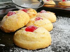 several cookies with jelly on them sitting on a baking sheet